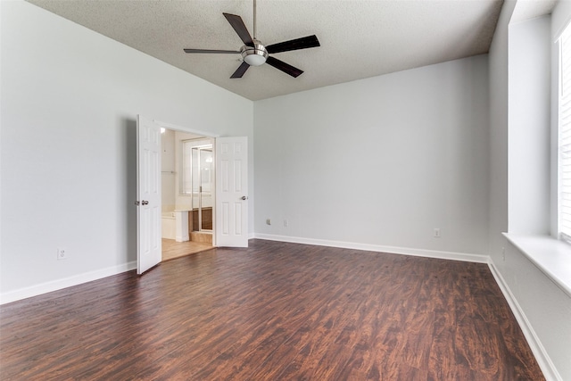 unfurnished bedroom with baseboards, dark wood-style flooring, a textured ceiling, and connected bathroom
