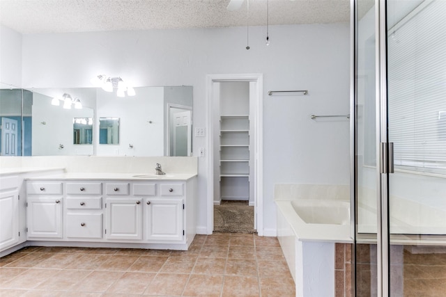 full bath with vanity, tile patterned flooring, ceiling fan, a bath, and a spacious closet