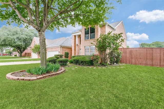view of front of home with an attached garage, a front lawn, driveway, and brick siding