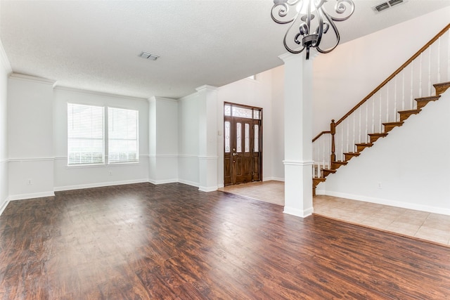 foyer entrance with a healthy amount of sunlight, an inviting chandelier, and wood finished floors