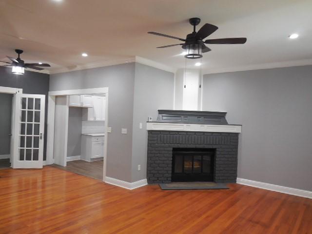 unfurnished living room with wood finished floors, ornamental molding, recessed lighting, and ceiling fan