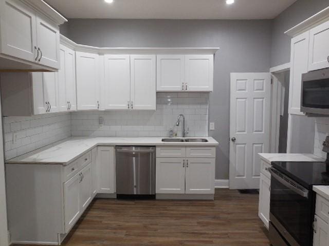 kitchen with backsplash, recessed lighting, stainless steel appliances, and a sink