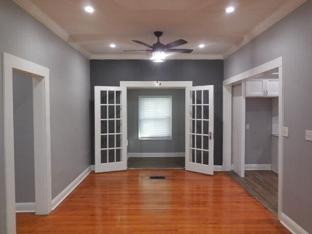 empty room with light wood-type flooring, ceiling fan, baseboards, ornamental molding, and recessed lighting