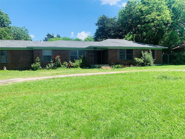ranch-style house featuring brick siding and a front yard