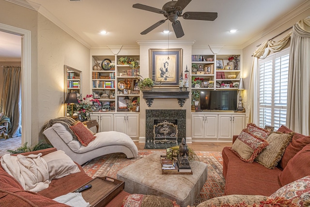 789 Fairmont Dr, Tyler, TX 75701 - living room featuring a ceiling fan, a premium fireplace, crown molding, light wood-style flooring, and built in shelves