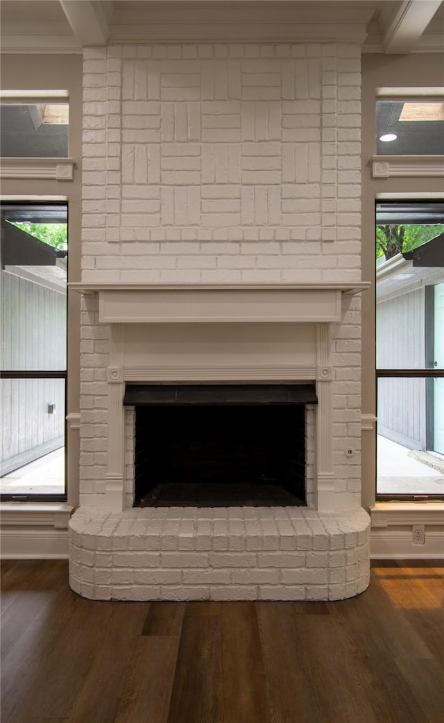 interior details featuring wood finished floors, a brick fireplace, and crown molding