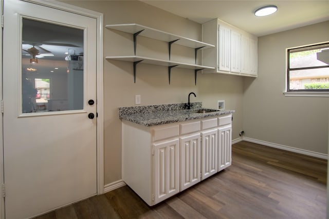 clothes washing area with a sink, cabinet space, baseboards, dark wood-style flooring, and washer hookup