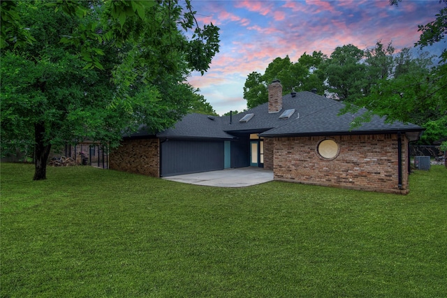 view of front of home featuring a front lawn, a chimney, roof with shingles, and brick siding