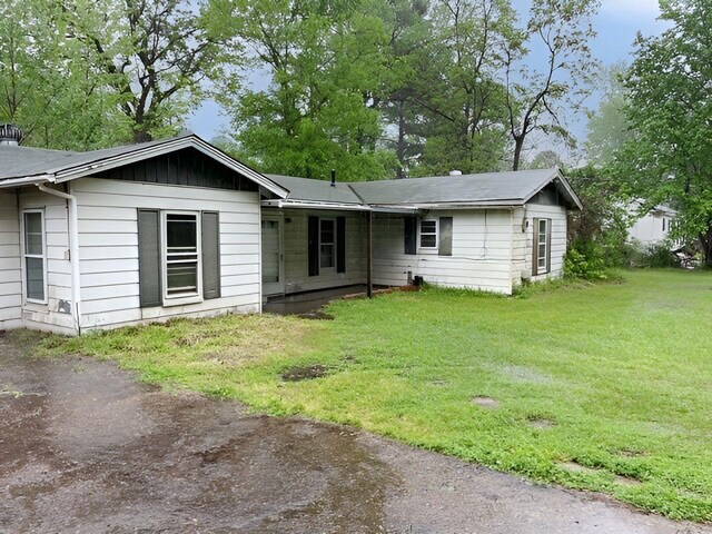 rear view of property featuring a yard