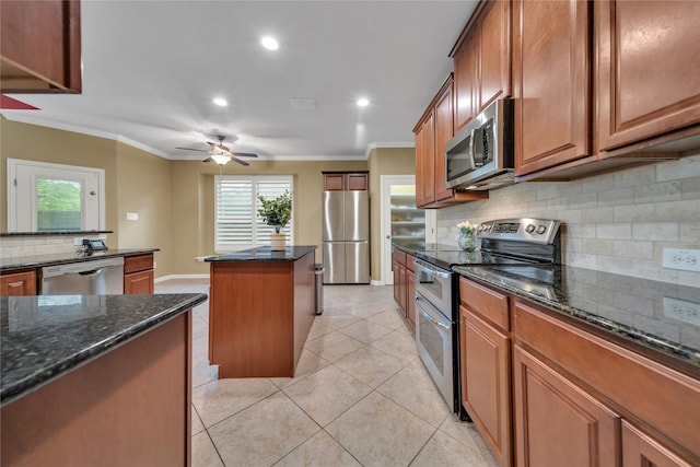 kitchen featuring decorative backsplash, ceiling fan, appliances with stainless steel finishes, ornamental molding, and a kitchen island
