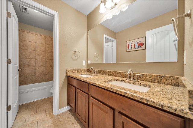full bath with visible vents, a sink, double vanity, and toilet