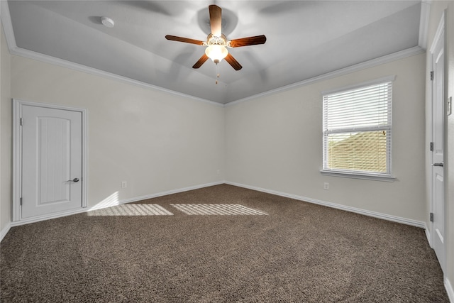carpeted empty room with ceiling fan, baseboards, ornamental molding, and a tray ceiling
