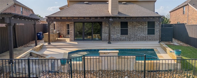back of property featuring a fenced backyard, brick siding, a patio area, and a shingled roof