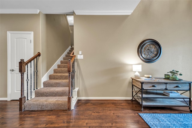 stairs with baseboards, crown molding, and wood finished floors