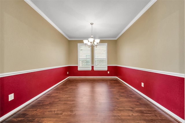 empty room featuring baseboards, wood finished floors, a notable chandelier, and crown molding