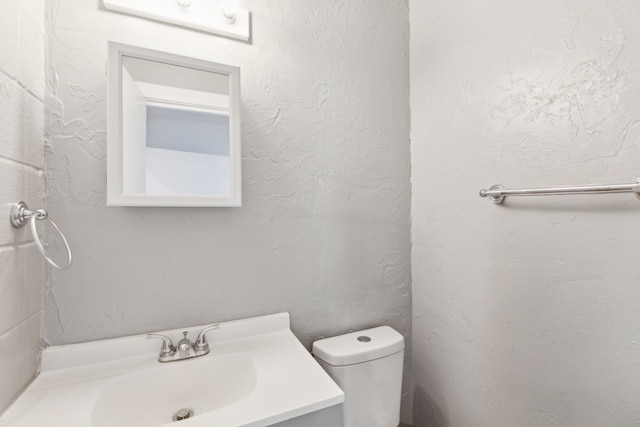 half bathroom with toilet and vanity