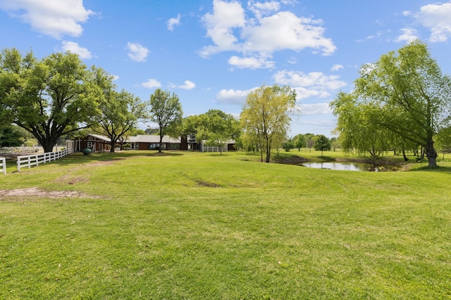 view of yard with fence and a water view