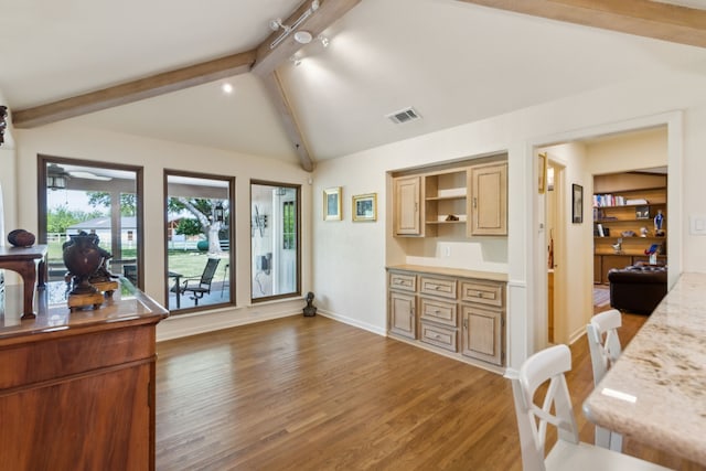 interior space featuring open shelves, wood finished floors, lofted ceiling with beams, baseboards, and visible vents