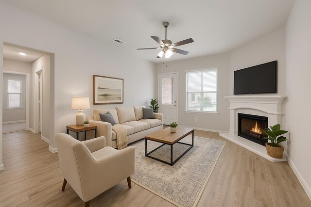 15044 Ted Trl, Aledo, TX 76008 - living room featuring ceiling fan, baseboards, light wood finished floors, and a lit fireplace