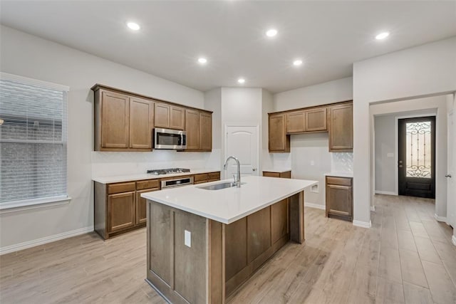 15044 Ted Trl, Aledo, TX 76008 - kitchen with a sink, appliances with stainless steel finishes, light wood finished floors, an island with sink, and light countertops