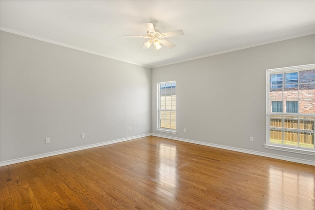 unfurnished room featuring ornamental molding, baseboards, wood finished floors, and ceiling fan