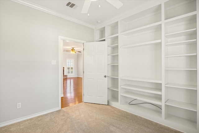 unfurnished bedroom featuring baseboards, visible vents, carpet floors, and ornamental molding