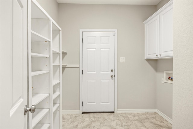 laundry area featuring baseboards, cabinet space, and washer hookup