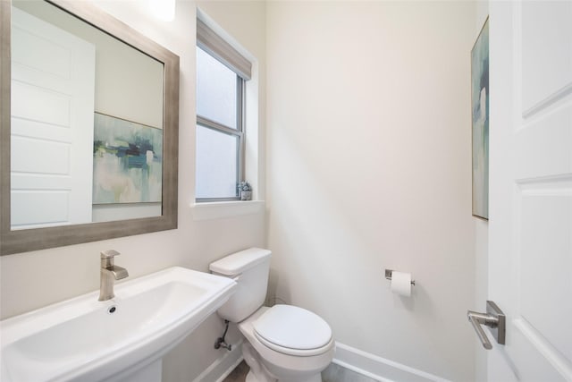 7112 Amber Grove Ct, Dallas, TX 75231 - half bathroom with toilet, baseboards, and a sink