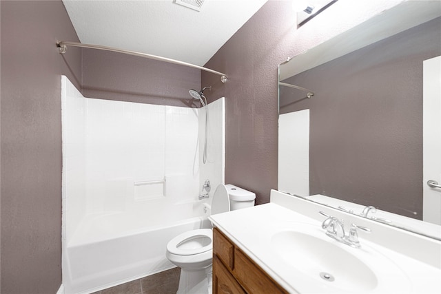 bathroom with tile patterned floors, a textured wall, shower / bath combination, toilet, and vanity