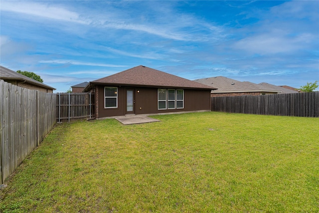 back of house featuring a lawn, a patio, and a fenced backyard
