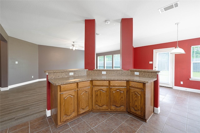 kitchen with ceiling fan, baseboards, visible vents, and light countertops