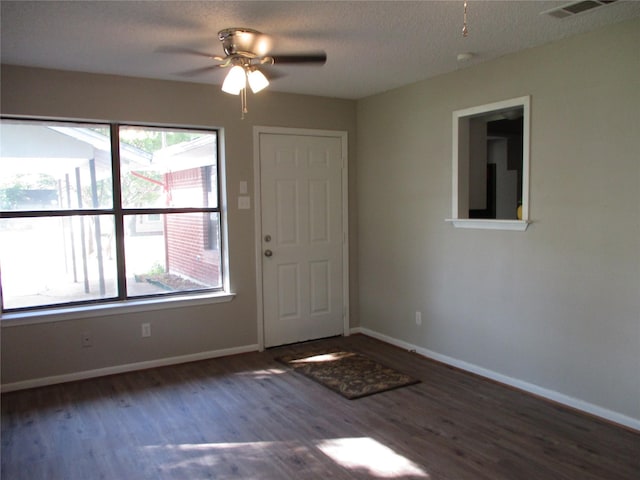 entrance foyer with wood finished floors, a healthy amount of sunlight, a ceiling fan, and visible vents