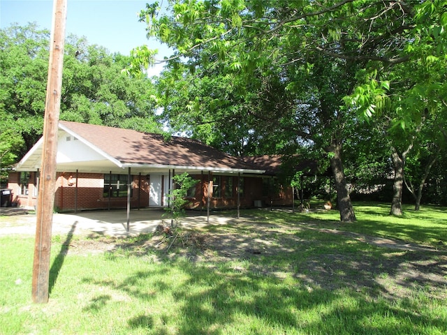 view of front of property featuring a shingled roof, a front yard, and an attached carport