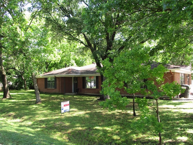 view of front of house with brick siding and a front yard