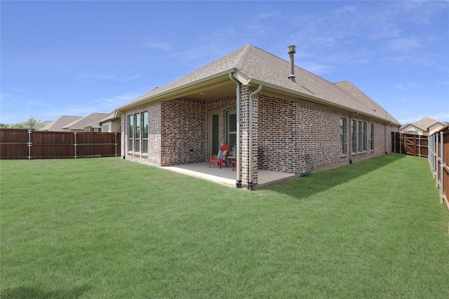 back of property with a fenced backyard, brick siding, a shingled roof, a patio, and a lawn