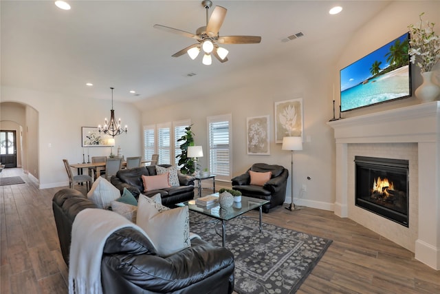 living area with a glass covered fireplace, arched walkways, visible vents, and a healthy amount of sunlight