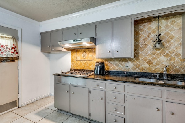4744 Richard St, Forest Hill, TX 76119 - kitchen featuring under cabinet range hood, a sink, crown molding, tasteful backsplash, and gray cabinetry