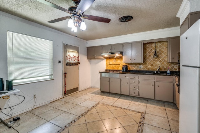 4744 Richard St, Forest Hill, TX 76119 - kitchen featuring under cabinet range hood, dark countertops, light tile patterned flooring, freestanding refrigerator, and ceiling fan