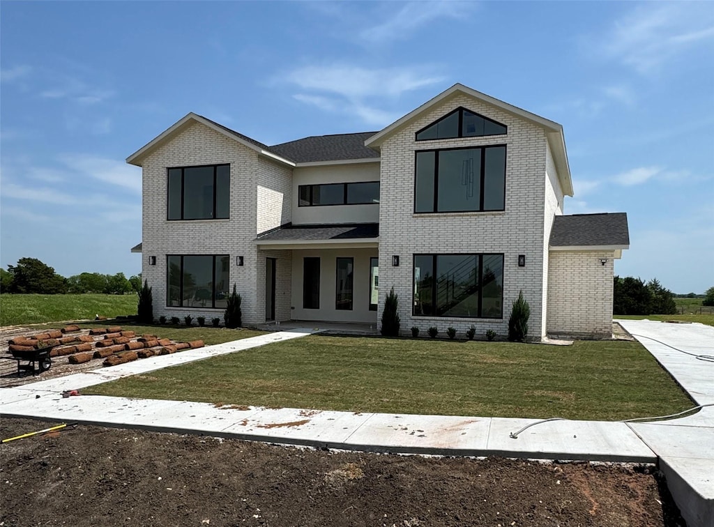modern farmhouse with a front lawn and brick siding