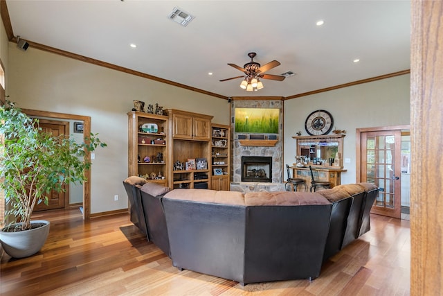 living room featuring light wood-style flooring, visible vents, recessed lighting, ceiling fan, and a fireplace
