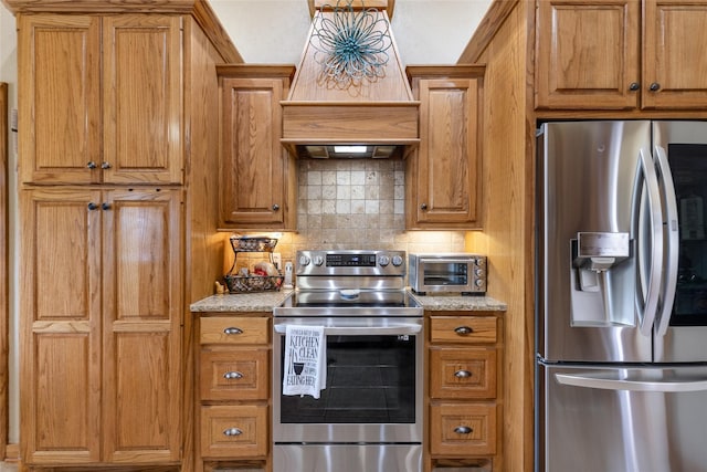 kitchen with custom exhaust hood, brown cabinets, decorative backsplash, a toaster, and stainless steel appliances