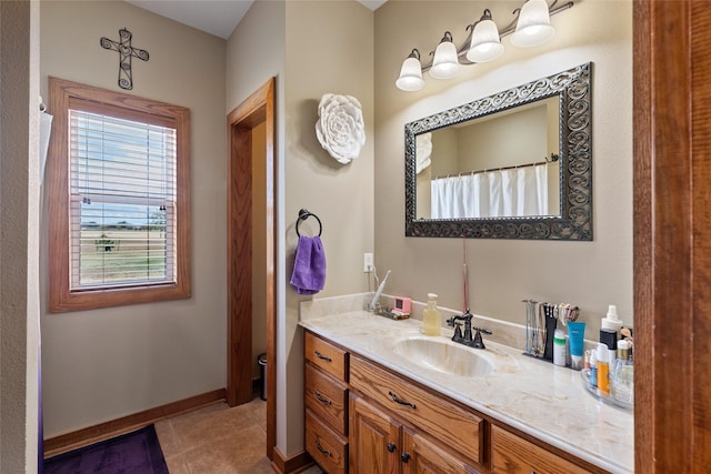 full bath with baseboards, tile patterned flooring, and vanity