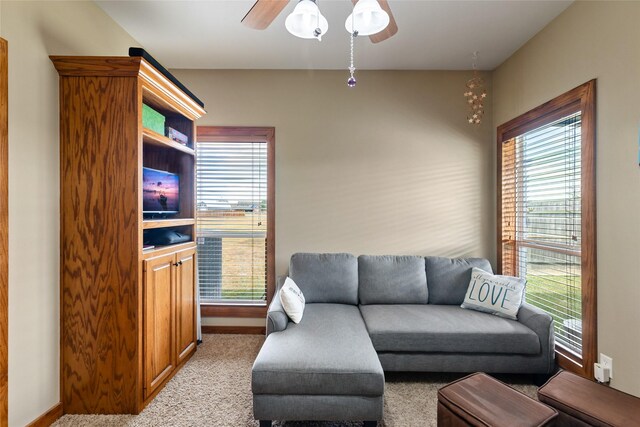 living area with ceiling fan, baseboards, a healthy amount of sunlight, and carpet