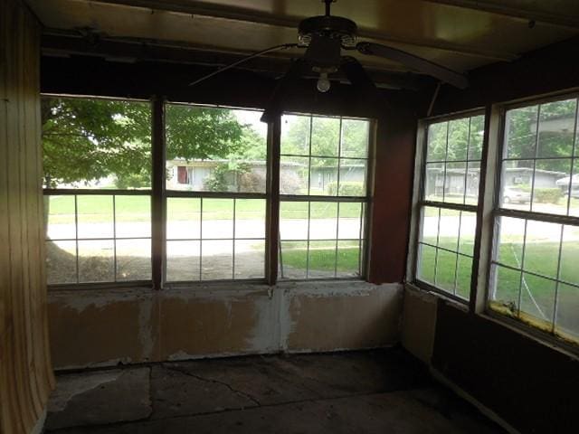 unfurnished sunroom featuring a ceiling fan