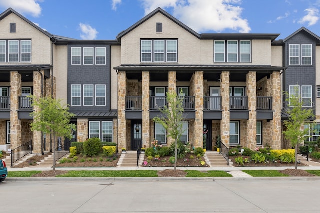 townhome / multi-family property with stone siding and a balcony