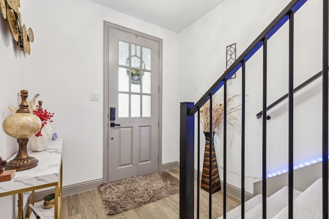 entrance foyer with baseboards, wood finished floors, and stairs