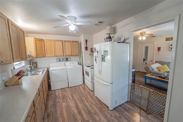 washroom featuring independent washer and dryer, visible vents, a ceiling fan, and a sink