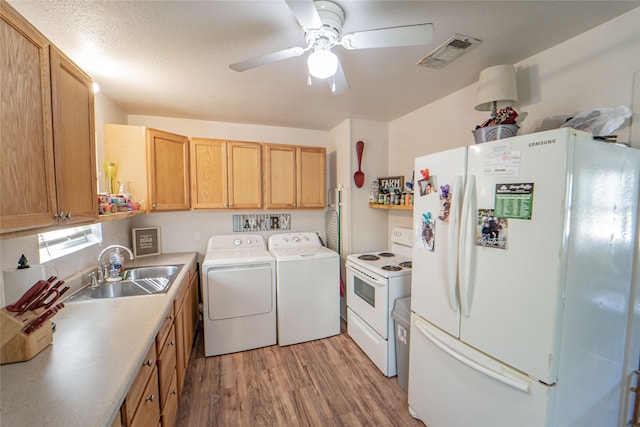 washroom with laundry area, visible vents, a sink, washing machine and clothes dryer, and light wood-style flooring