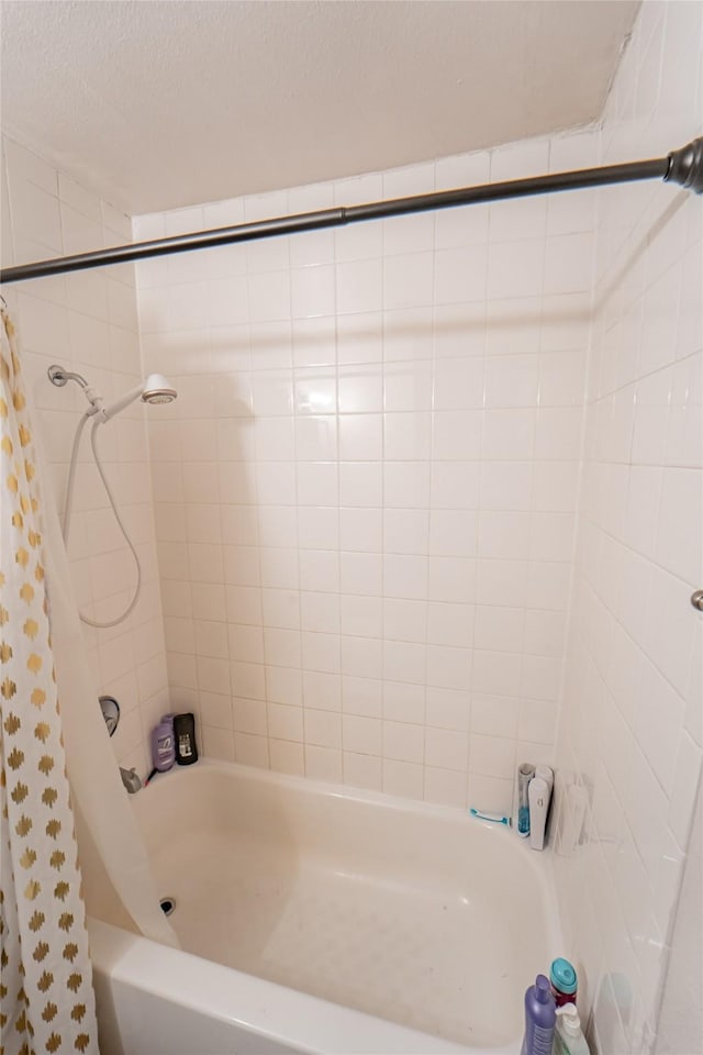 full bathroom featuring shower / bath combo and a textured ceiling