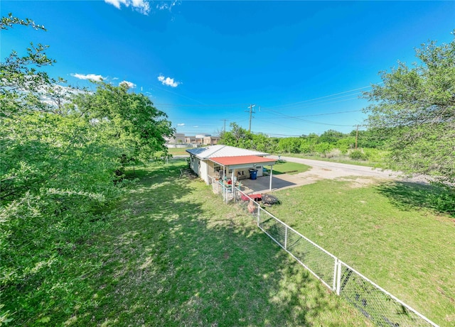 view of yard featuring fence, driveway, and a carport